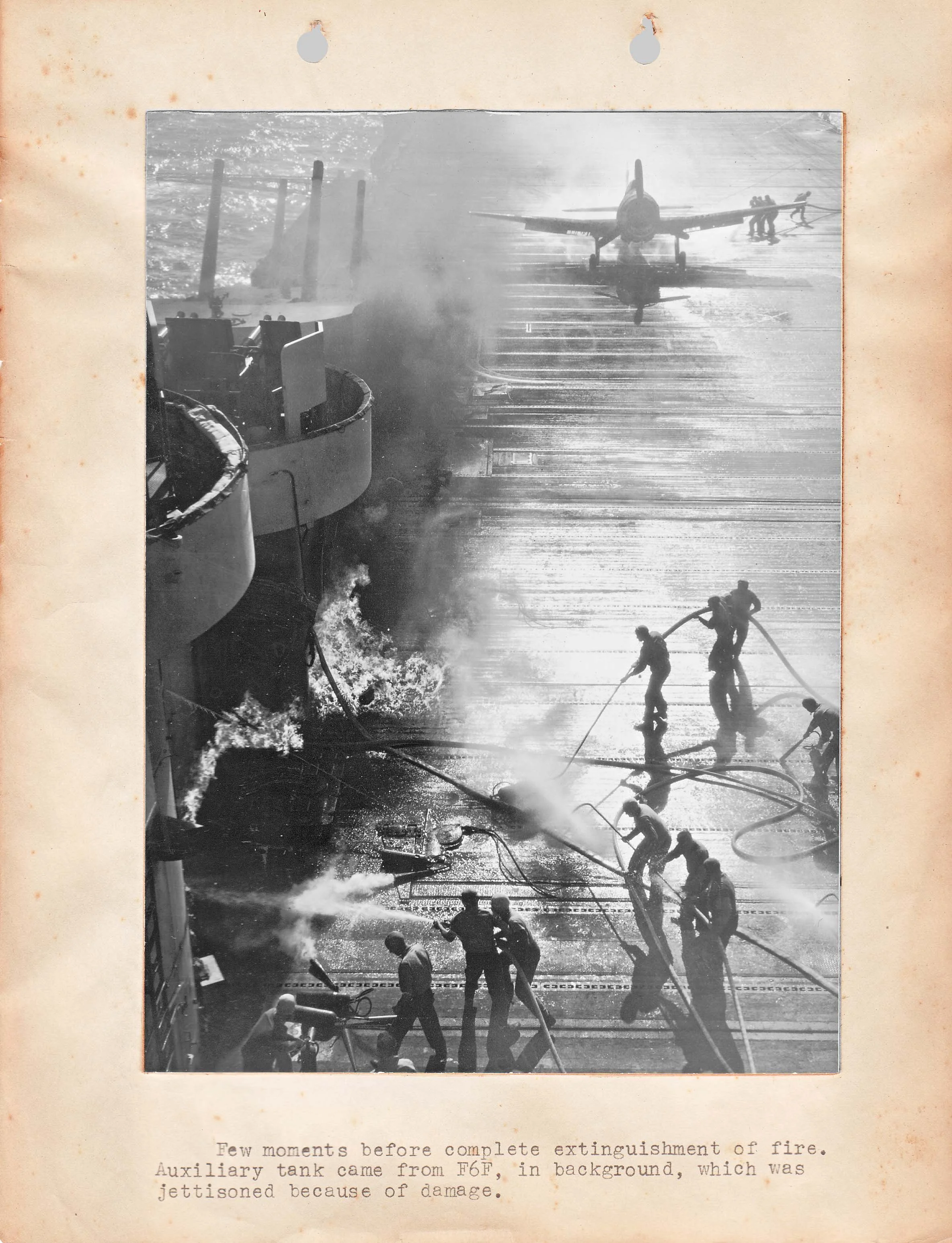 A fire on the Essex flight deck after a belly tank breaks away from an F6F Hellcat after land...webp