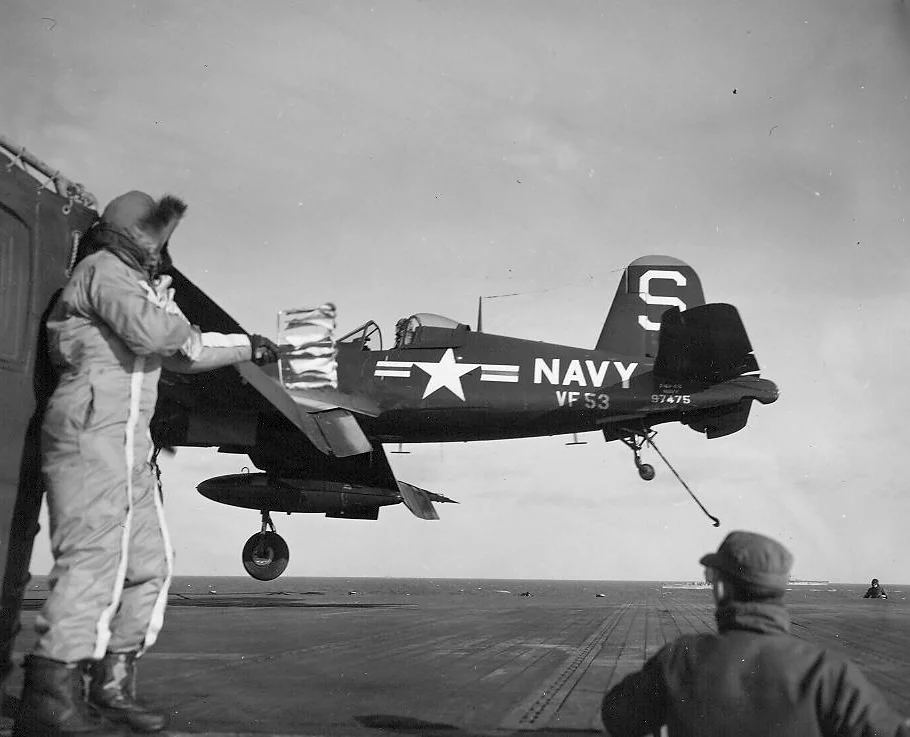 A Landing Signal Officer (LSO) waves an F4U-4B Corsair of Fighter Squadron (VF) 53 aboard the...webp