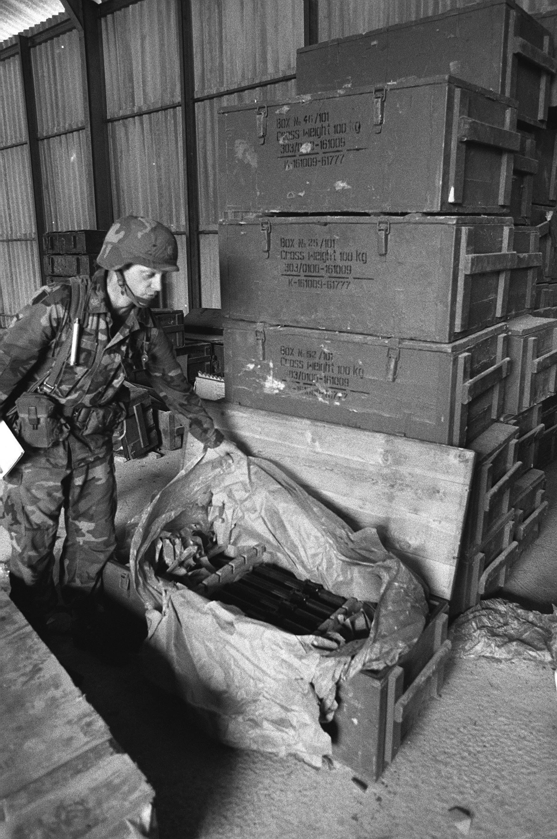 a-member-of-the-82nd-airborne-division-examines-a-crate-of-weapons-seized-during-90d1f5.jpg