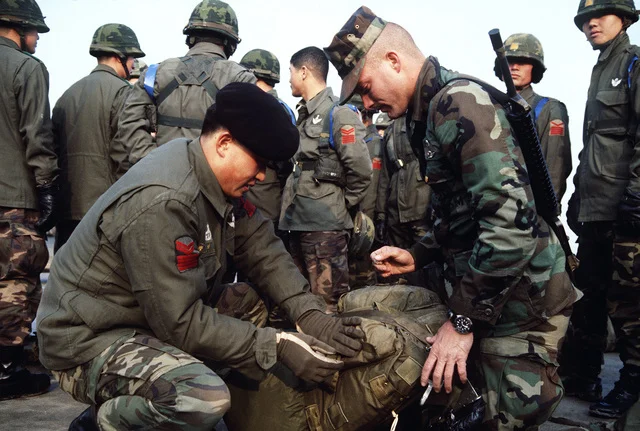 a-us-army-paratrooper-helps-a-korean-counterpart-ready-his-gear-before-an-airdrop-04e105-640.webp