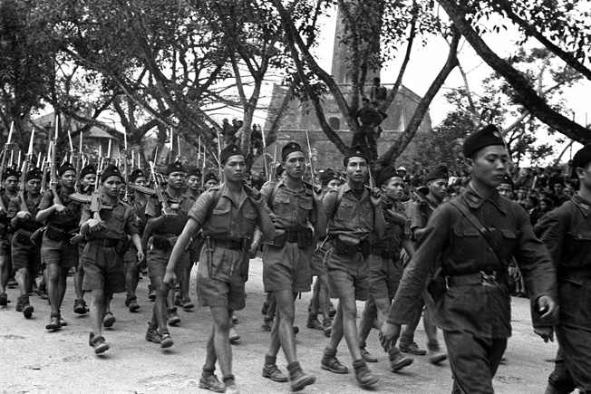 Communist soldiers loyal to Ho Chi Minh parade through the streets of Hanoi.jpg