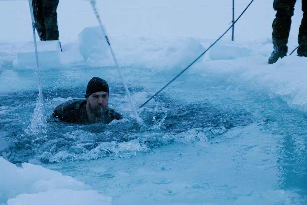 Ein-Gebirgsjäger-kämpft-sich-durch-das-eiskalte-Wasser..webp