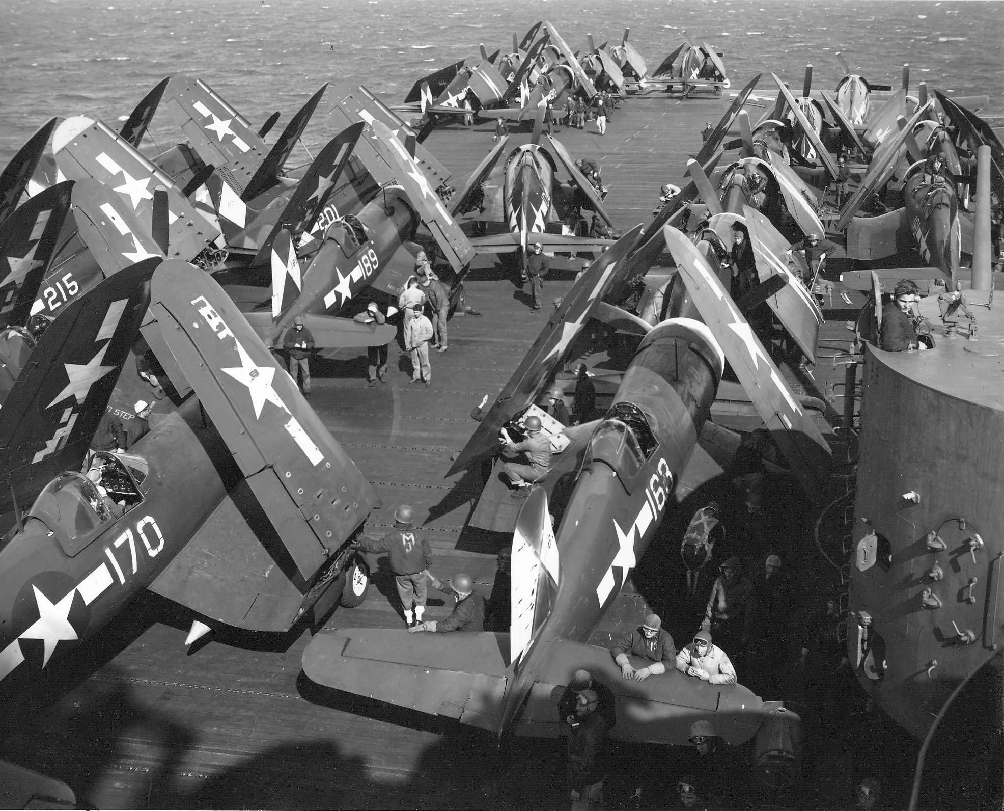 F4U Corsairs and F6F Hellcats of Air Group 83 pictured on the flight deck of the carrier Esse...webp