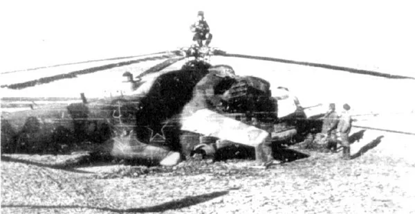 Mi-24 V-VS en Afganistan 42, tras aterrizaje emergencia, con tecnicos evaluando daño 1981 (G. ...jpg