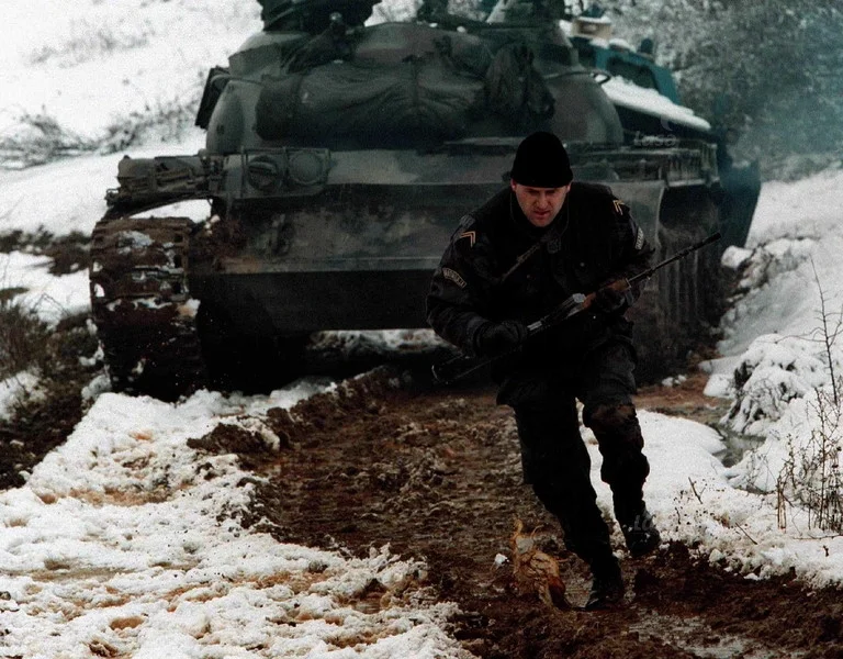 Serbian policeman runs for cover during a firefight with the KLA near the village of Bukos, T...webp