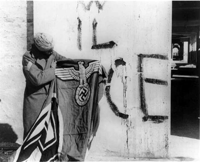 Sikh soldier of the 11th Sikh Regiment with a captured Nazi flag in Italy.jpg