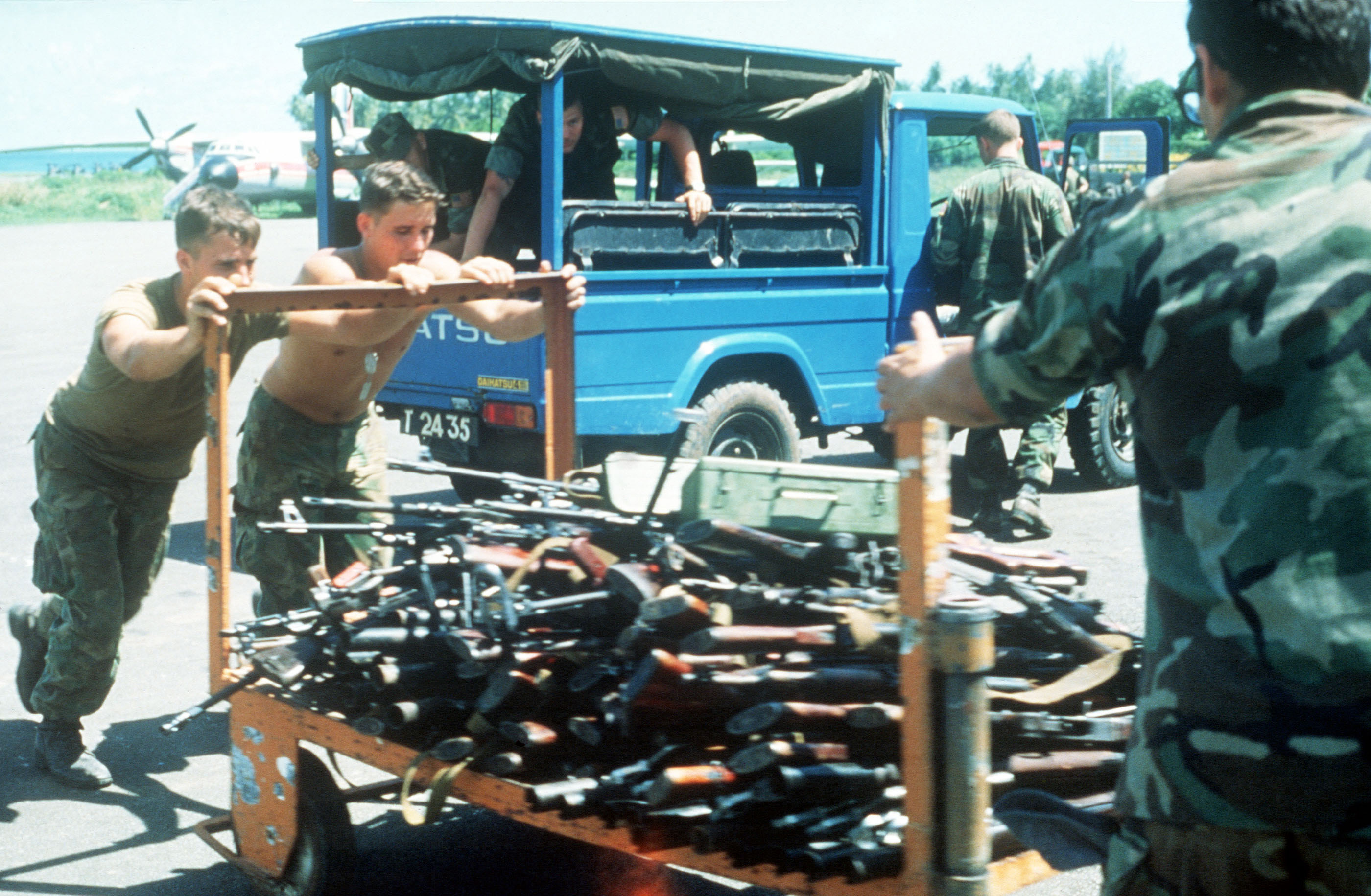 us-military-personnel-push-a-cart-loaded-with-weapons-seized-during-operation-800cde.jpg