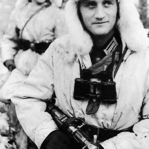 A German officer is posing for a camera, he's wearing the reversible winter uniform, which is white for use in the depicted conditions but multicolored in greens and browns on the reverse side in Southern Russia (Winter 1943/44)