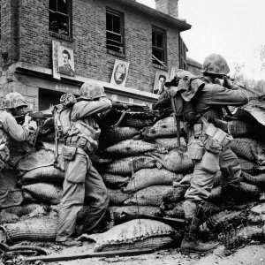 U.S Marines take cover behind sandbags during an engagement with KPA forces in a Korean town, 1953