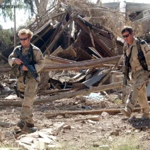 Two combat controllers inspect a building