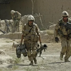 Soldiers run across a compound after receiving gun fire