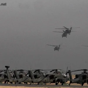 AH-64 Apache helicopters wait on the flight line