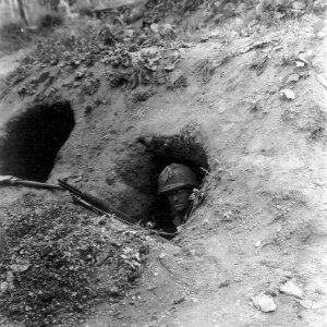 1944 WWII US soldier seeks cover in foxhole Saint-Lô, Normandy, France 23 July 1944