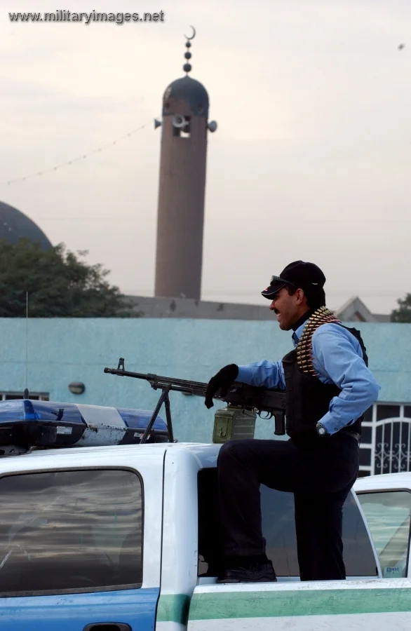 Iraqi police officer stands ready for a patrol