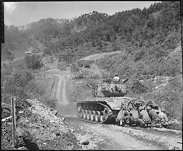 Marine Infantrymen Take Cover Behind A Tank While It Fires O