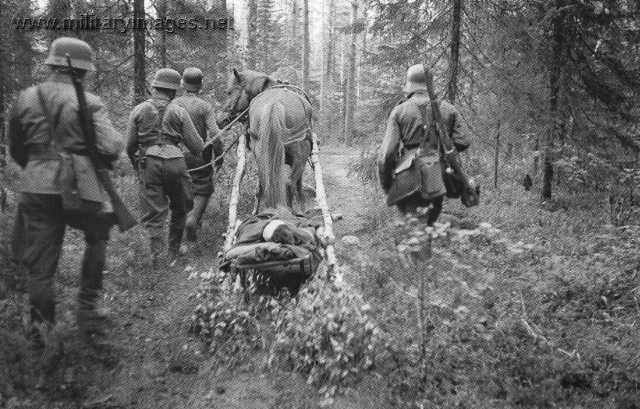 Wounded soldier being transported in woods