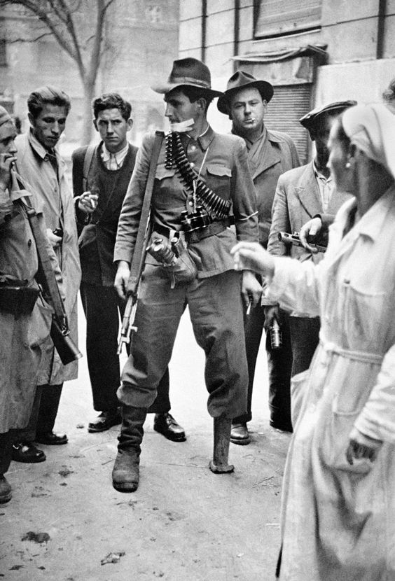 HUNGARY. BUDAPEST. Hungarian Revolution. A freedom fighter in Budapest, during a lull in the fighting, talks to other freedom fighters and seems oblivious of the problems that having a wooden leg must cause in such a situation. 1956.